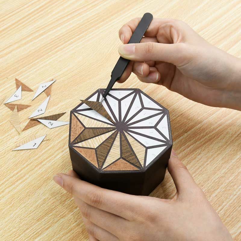 はさみで切ってシール状になった天然木のシートを下絵に貼るだけ