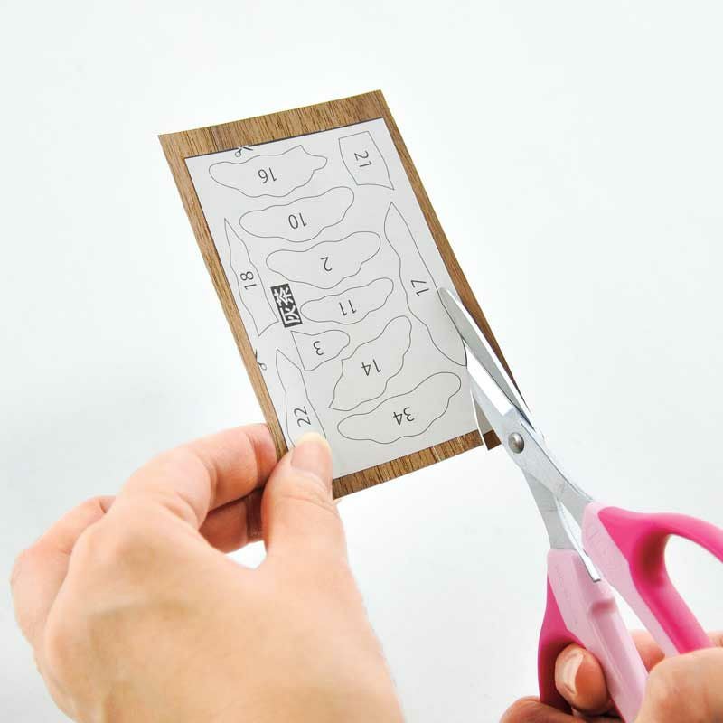 はさみで切った天然木のパーツを下絵に貼ります